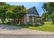 Exterior side elevation featuring stone details, a covered porch, and a neatly landscaped yard at 11315 House St, Indianapolis, IN 46259