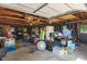 Cluttered garage interior with exposed rafters and concrete flooring used for storage at 11315 House St, Indianapolis, IN 46259