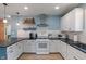Bright kitchen with white cabinets, subway tile, and a black countertop with white appliances at 11315 House St, Indianapolis, IN 46259