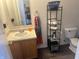 Bathroom featuring a vanity with sink, mirror, and storage shelves, plus toilet and towel rack at 12536 Teacup Ne Way, Indianapolis, IN 46235