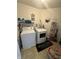 Laundry room with washer, dryer, shelving, and laundry-themed decor at 12536 Teacup Ne Way, Indianapolis, IN 46235