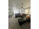 Bright living room featuring a large sectional couch, modern light fixture, and many windows at 12536 Teacup Ne Way, Indianapolis, IN 46235