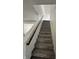 Carpeted staircase leading to the upper level of the home with natural wood at 12536 Teacup Ne Way, Indianapolis, IN 46235