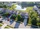 A neighborhood showcases well-maintained homes with lush landscaping and a tranquil pond, aerial view at 12847 Arvada Pl, Fishers, IN 46038