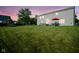 Spacious backyard featuring a patio with an umbrella table, a playset, and ample green space at sunset at 12847 Arvada Pl, Fishers, IN 46038