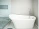 Elegant bathroom with a modern white standalone bathtub and tiled floor at 12847 Arvada Pl, Fishers, IN 46038