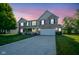 Charming two-story home with well-manicured lawn and inviting front porch at dusk at 12847 Arvada Pl, Fishers, IN 46038