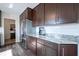 Bright kitchen with stainless steel refrigerator, granite countertops, and wood grain flooring at 12847 Arvada Pl, Fishers, IN 46038