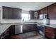 Modern kitchen features stainless steel appliances, granite countertops and dark brown cabinets at 12847 Arvada Pl, Fishers, IN 46038