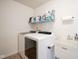 Laundry room with a white washer and dryer, sink, and shelving for storage at 12847 Arvada Pl, Fishers, IN 46038