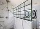 Bathroom features modern fixtures, marble tile, black grid shower door and a gray vanity at 12997 Bartlett Dr, Fishers, IN 46037