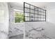 Modern bathroom features marble tile, a window for natural light, and a sleek glass-enclosed shower at 12997 Bartlett Dr, Fishers, IN 46037
