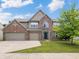 Attractive two-story brick home with a well-manicured lawn and a three-car garage at 12997 Bartlett Dr, Fishers, IN 46037