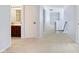 Hallway featuring plush carpet, neutral walls, and entry to bathroom with vanity at 12997 Bartlett Dr, Fishers, IN 46037