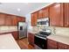 Kitchen featuring stainless steel appliances, tile backsplash, wood cabinets, and a kitchen island at 12997 Bartlett Dr, Fishers, IN 46037