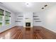 The bright living room is equipped with hardwood floors, a fireplace, and custom shelving at 12997 Bartlett Dr, Fishers, IN 46037