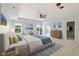 Airy main bedroom featuring a ceiling fan, sitting area, and a dresser against the back wall at 12997 Bartlett Dr, Fishers, IN 46037
