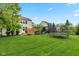 Spacious backyard with lush green grass, mature trees, a trampoline, and a charming pergola for outdoor entertaining at 12998 Silbury Hill Way, Fishers, IN 46037