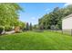Expansive backyard with a well-maintained lawn, mature trees, landscaping, and a fenced perimeter for privacy at 12998 Silbury Hill Way, Fishers, IN 46037