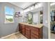 Bathroom with double sink vanity, granite countertop, large mirror, natural light, and walk-in closet access at 12998 Silbury Hill Way, Fishers, IN 46037
