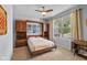 Comfortable bedroom with a built-in Murphy bed, shelving, and natural light from a large window at 12998 Silbury Hill Way, Fishers, IN 46037