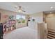 Bright upstairs bedroom with carpet flooring, ceiling fan, a large window, and staircase access at 12998 Silbury Hill Way, Fishers, IN 46037