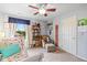 Bright bedroom features a comfortable chair, ceiling fan, and built in bookshelf at 12998 Silbury Hill Way, Fishers, IN 46037