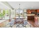 Dining area with a rustic table, modern chandelier, and large windows offering abundant natural light at 12998 Silbury Hill Way, Fishers, IN 46037