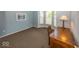 Well-lit bedroom area featuring large windows and neutral carpeting, adjacent to a wood desk at 13161 Duval Dr, Fishers, IN 46037