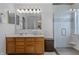 Bathroom featuring a double vanity sink, large mirror, and a glass-enclosed shower with tile accents at 1319 Gable Lake Dr, Brownsburg, IN 46112