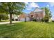 Beautiful brick home with a manicured lawn, mature trees, and an attached two-car garage at 1319 Gable Lake Dr, Brownsburg, IN 46112