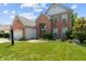 Stately brick home with well-kept lawn and landscaping, attached garage, and elegant architectural details at 1319 Gable Lake Dr, Brownsburg, IN 46112