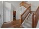 Welcoming foyer with hardwood floors, staircase, wooden railing and trim, and access to other rooms at 1319 Gable Lake Dr, Brownsburg, IN 46112