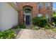 Welcoming front entrance with a brick facade, arched doorway, and landscaped garden bed at 1319 Gable Lake Dr, Brownsburg, IN 46112