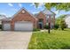 Charming brick two-story home with well-manicured lawn and two-car garage on a sunny day at 1319 Gable Lake Dr, Brownsburg, IN 46112