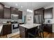 Updated kitchen featuring dark cabinets, stainless steel appliances, granite counters, and a center island at 1319 Gable Lake Dr, Brownsburg, IN 46112