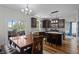 Open kitchen with granite countertops, stainless appliances, dark wood cabinets, and an adjacent dining area with sliding glass doors at 1319 Gable Lake Dr, Brownsburg, IN 46112