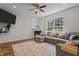 Cozy living room featuring a fireplace, large windows, ceiling fan, and a comfortable sectional sofa on top of decorative rug at 1319 Gable Lake Dr, Brownsburg, IN 46112