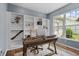 Bright home office with custom built-in shelves, hardwood floors, and a large window providing ample natural light at 1319 Gable Lake Dr, Brownsburg, IN 46112