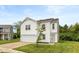 Charming two-story home features a white exterior, attached garage, and well-manicured front yard at 1338 Delacorte Cir, Shelbyville, IN 46176