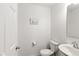 Bright half-bathroom featuring tile floors, toilet, sink and vanity, and a 'Blessed' sign at 1338 Delacorte Cir, Shelbyville, IN 46176