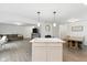Open-concept kitchen featuring a marble island, stainless appliances, and views into the living and dining areas at 1338 Delacorte Cir, Shelbyville, IN 46176