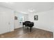 Bright living room with wood floors, a black piano, natural light, and neutral-colored walls at 1338 Delacorte Cir, Shelbyville, IN 46176