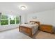 Main bedroom features natural light, a wooden bed frame, and neutral decor at 1338 Delacorte Cir, Shelbyville, IN 46176