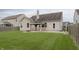 View of backyard featuring a covered patio with curtains and a grassy area surrounded by a wooden fence at 14332 Eddington Pl, Fishers, IN 46037