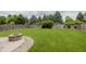 Lush backyard with a stone fire pit and a fenced perimeter at 14332 Eddington Pl, Fishers, IN 46037
