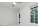Sunlit bedroom with neutral carpet, an open door, and a bright window overlooking green outdoors at 14332 Eddington Pl, Fishers, IN 46037