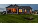 Landscaped backyard of craftsman home featuring covered porch with string lights and well maintained lawn at 19009 Beverly Shones Ln, Noblesville, IN 46062
