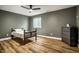 Cozy bedroom with vinyl plank flooring, a window and a dark green accent wall at 19009 Beverly Shones Ln, Noblesville, IN 46062