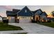 Beautiful two-story home with a three-car garage, illuminated by warm exterior lighting and surrounded by manicured lawns at 19009 Beverly Shones Ln, Noblesville, IN 46062